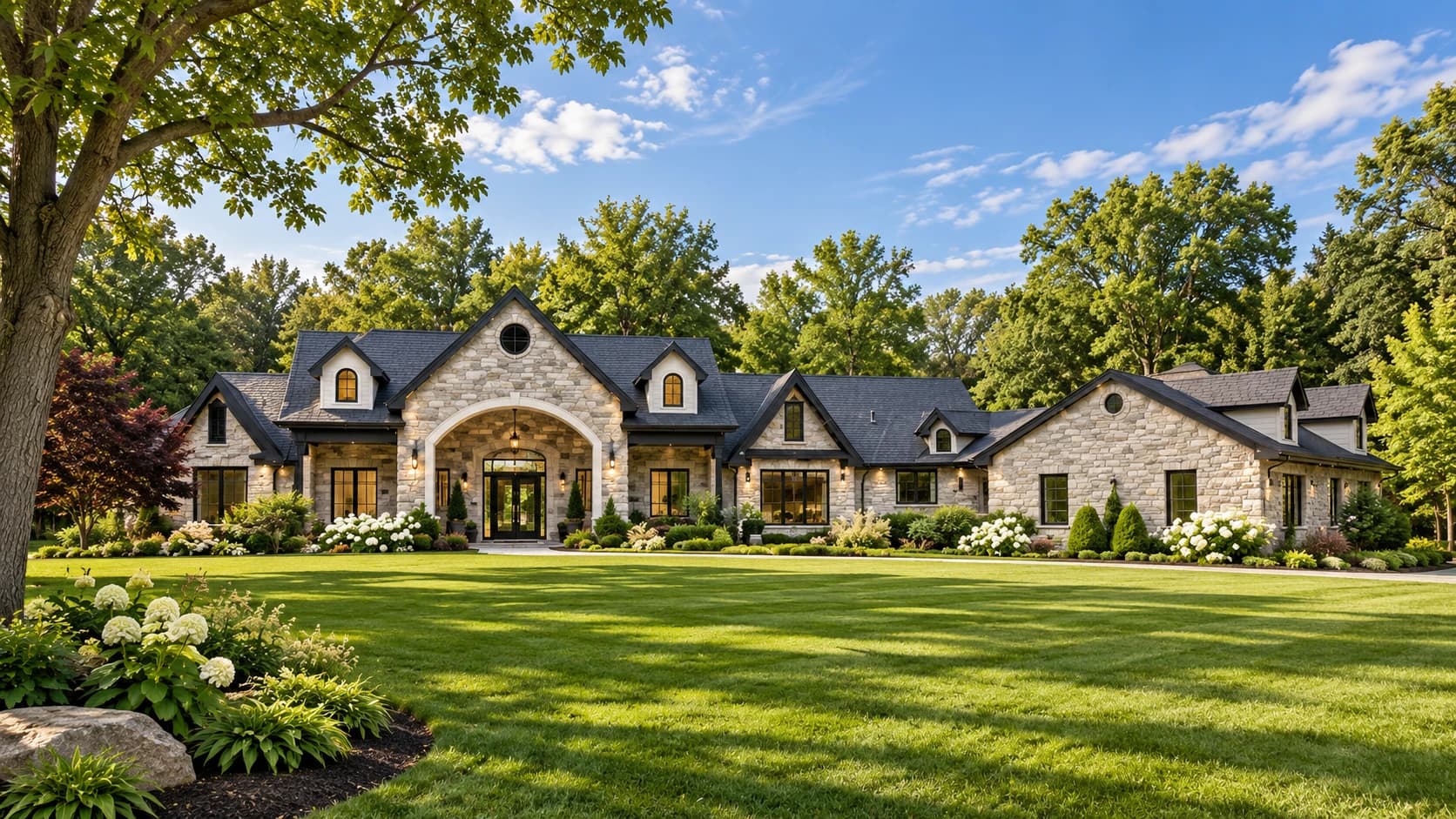 Visualization of a stone house with a large arched entrance, roof dormers, broad lawns, flowering gardens and mature trees
