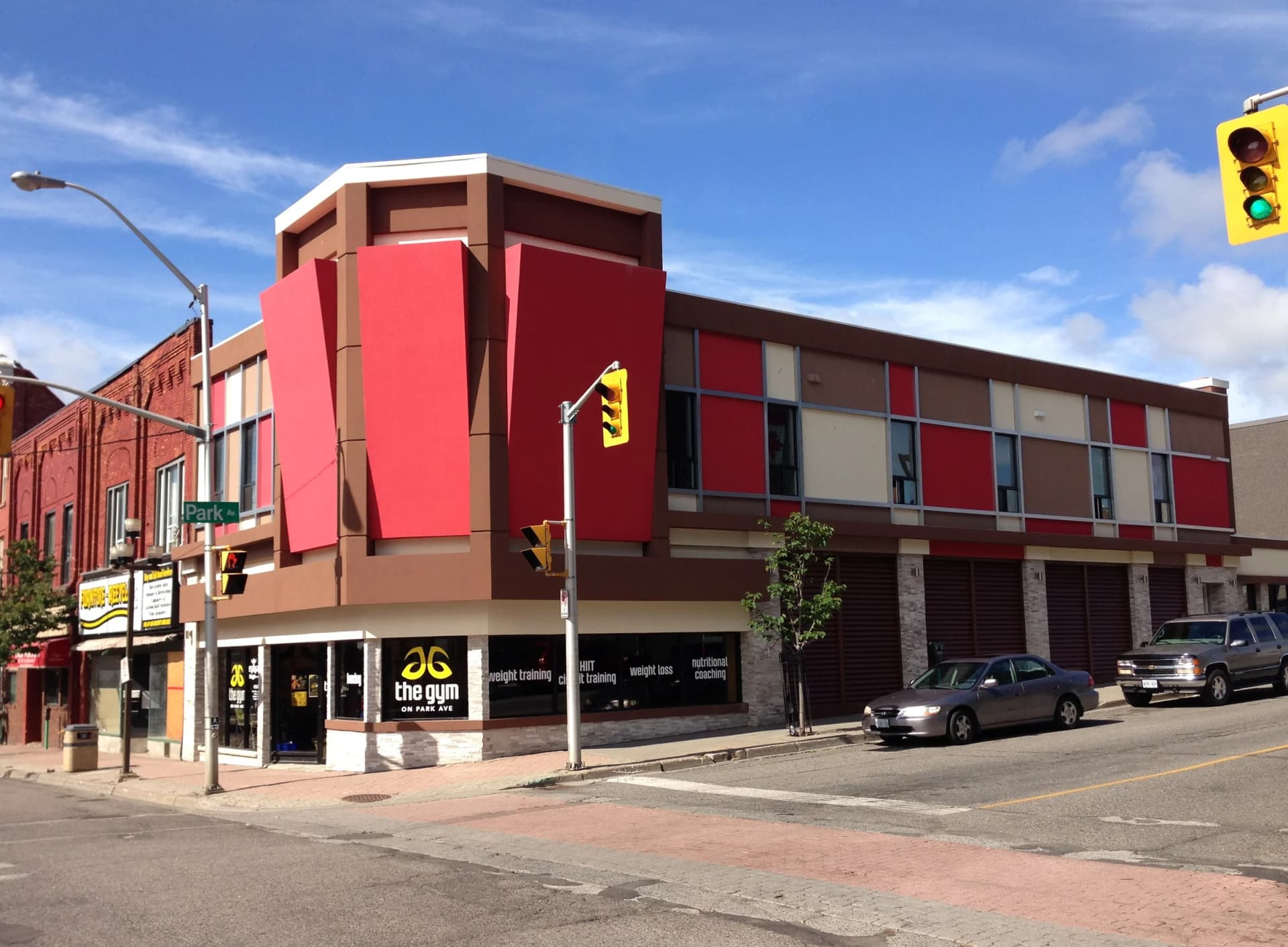 Mixed use building at 30 Cumberland Street South in Thunder Bay with red facade panels and stone-clad ground-floor storefronts