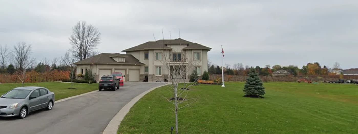 Supplied roadside photograph of 2367 Fourth Avenue showing the sloping driveway, parked vehicles, house and broad lawn