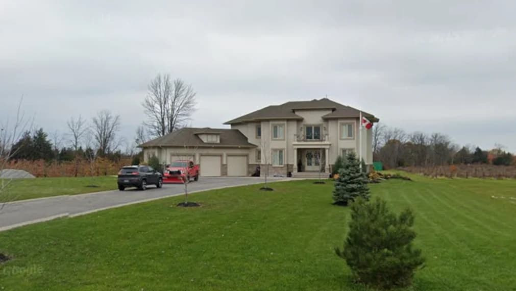 Supplied photograph of 2367 Fourth Avenue from across the lawn showing the house, garage wing, driveway and parked vehicles