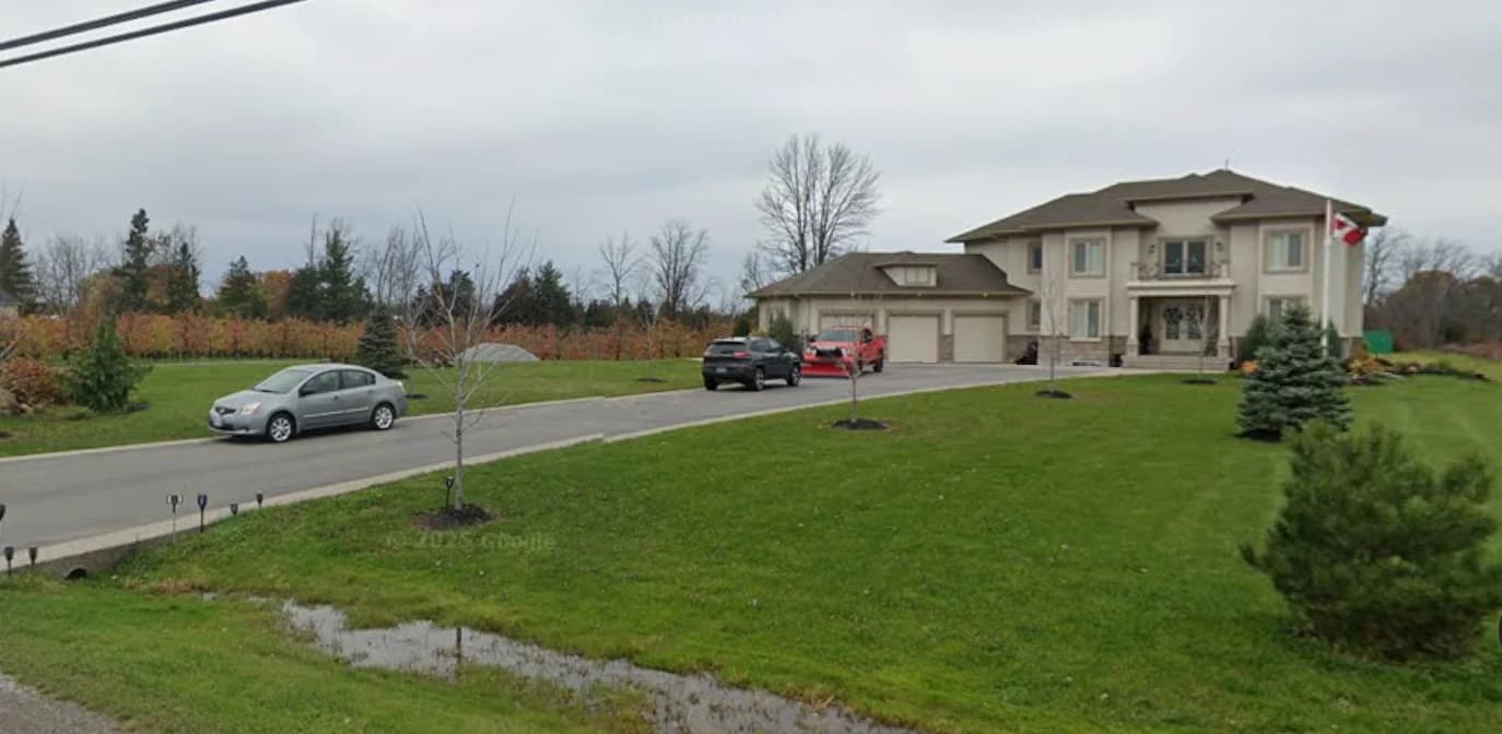 Wide supplied photograph of the frontage at 2367 Fourth Avenue with the house, lawn, young trees, driveway and roadside drainage ditch