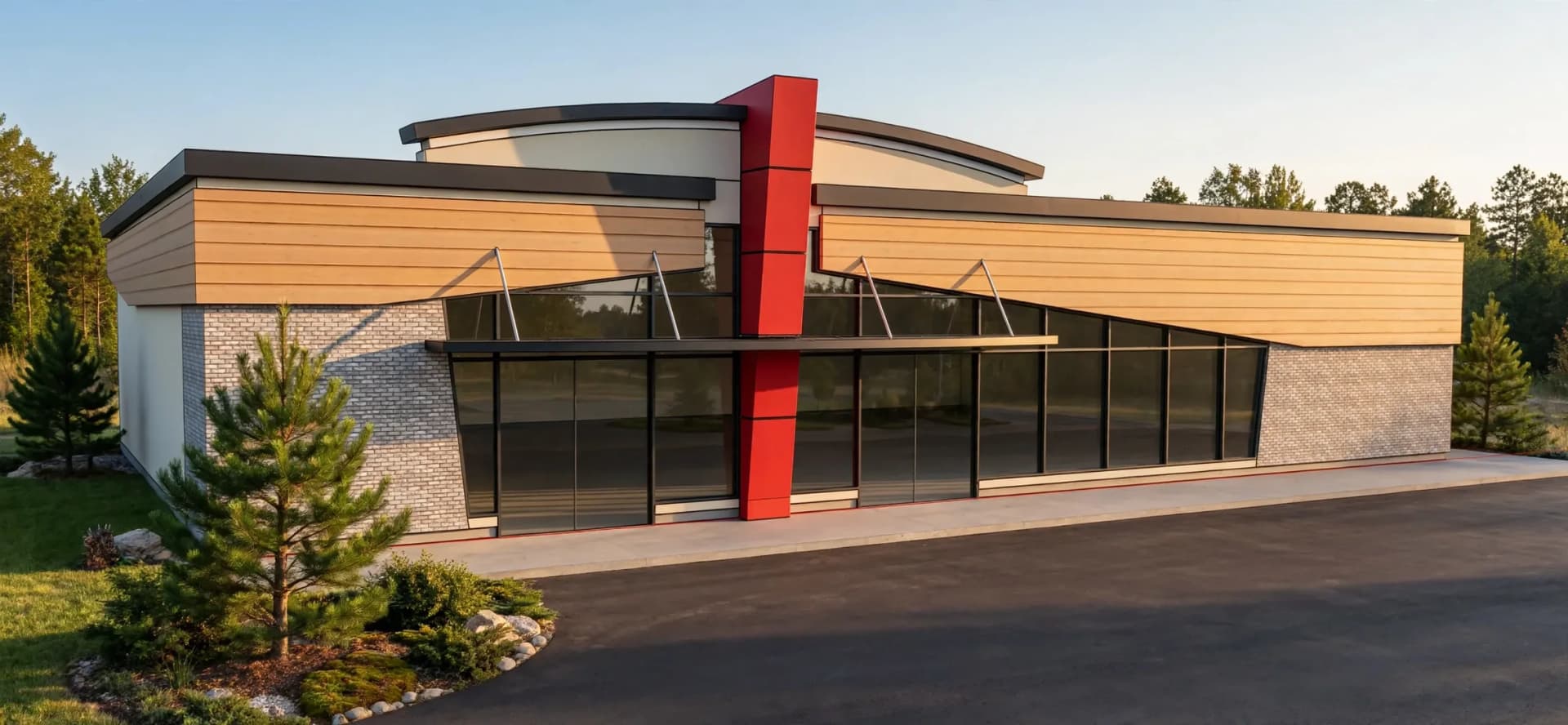 Commercial building at 4420 Drummond Road in Niagara Falls with pale brick, horizontal cladding, broad glazing, a curved roofline and a red vertical accent