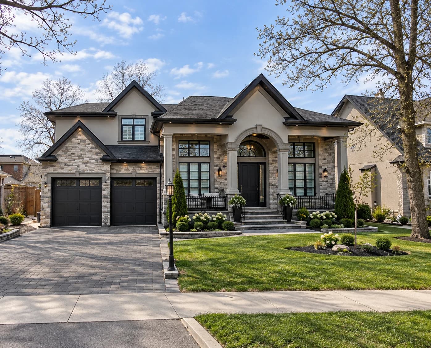 Supplied exterior visualization of 232 Sable Street with stone and stucco walls, front-facing gables, an arched entrance, a covered porch and two garage doors