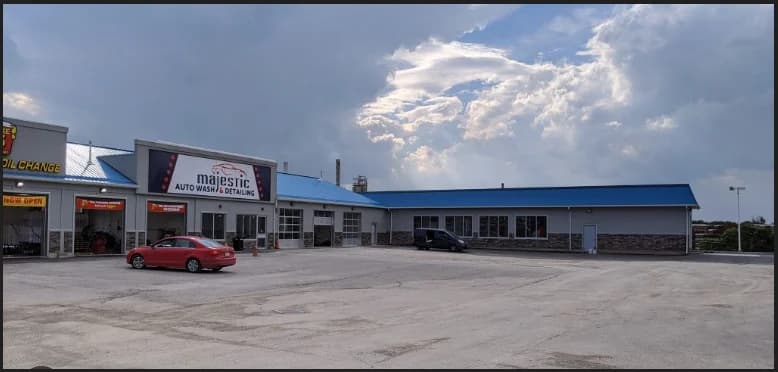 Supplied photograph of Majestic Auto Wash and Detailing showing its frontage sign, vehicle bays, blue roof and forecourt on an overcast day