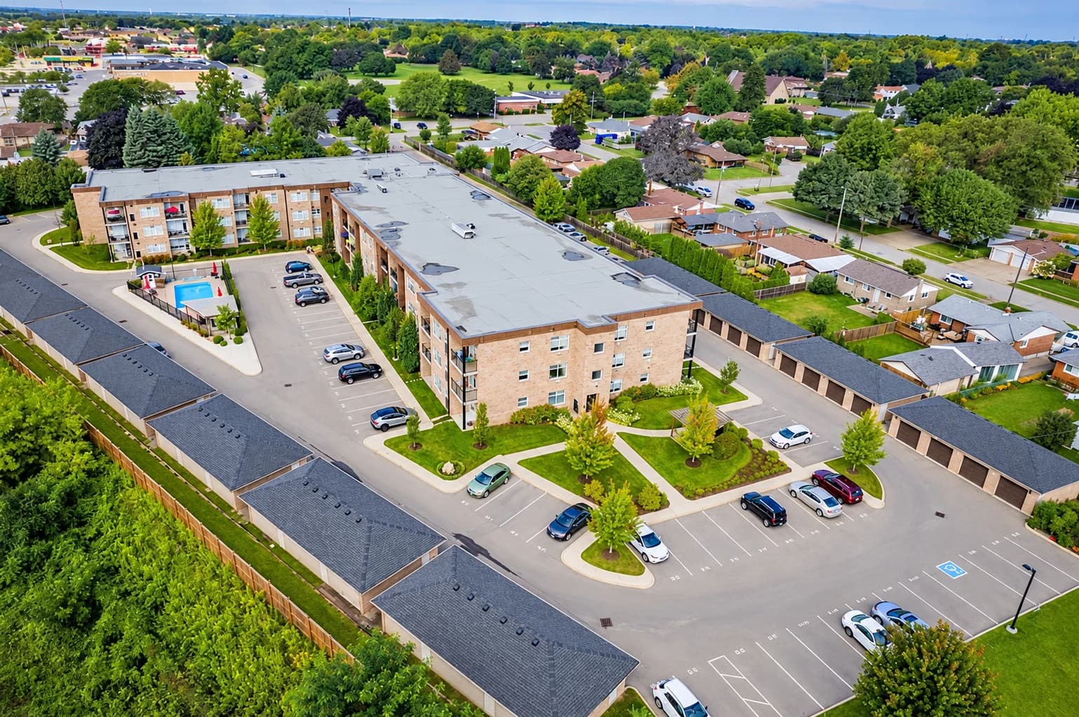 Aerial view of Olympia's courtyard, outdoor pool, garages and surrounding residential neighbourhood