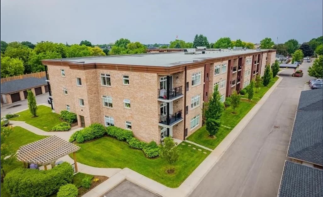 Aerial view of Olympia's three-storey brick building, private balconies, landscaped garden and timber pergola