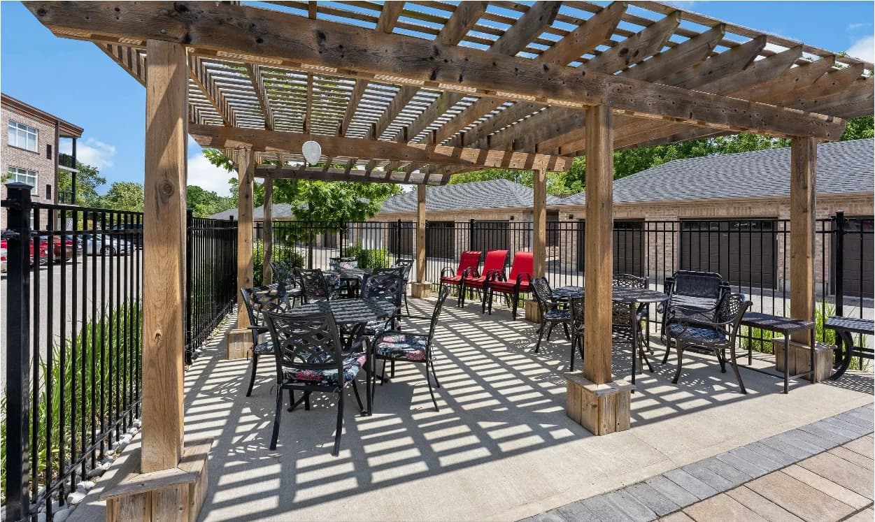 Timber pergola shading tables and chairs on Olympia's shared outdoor terrace beside brick garages