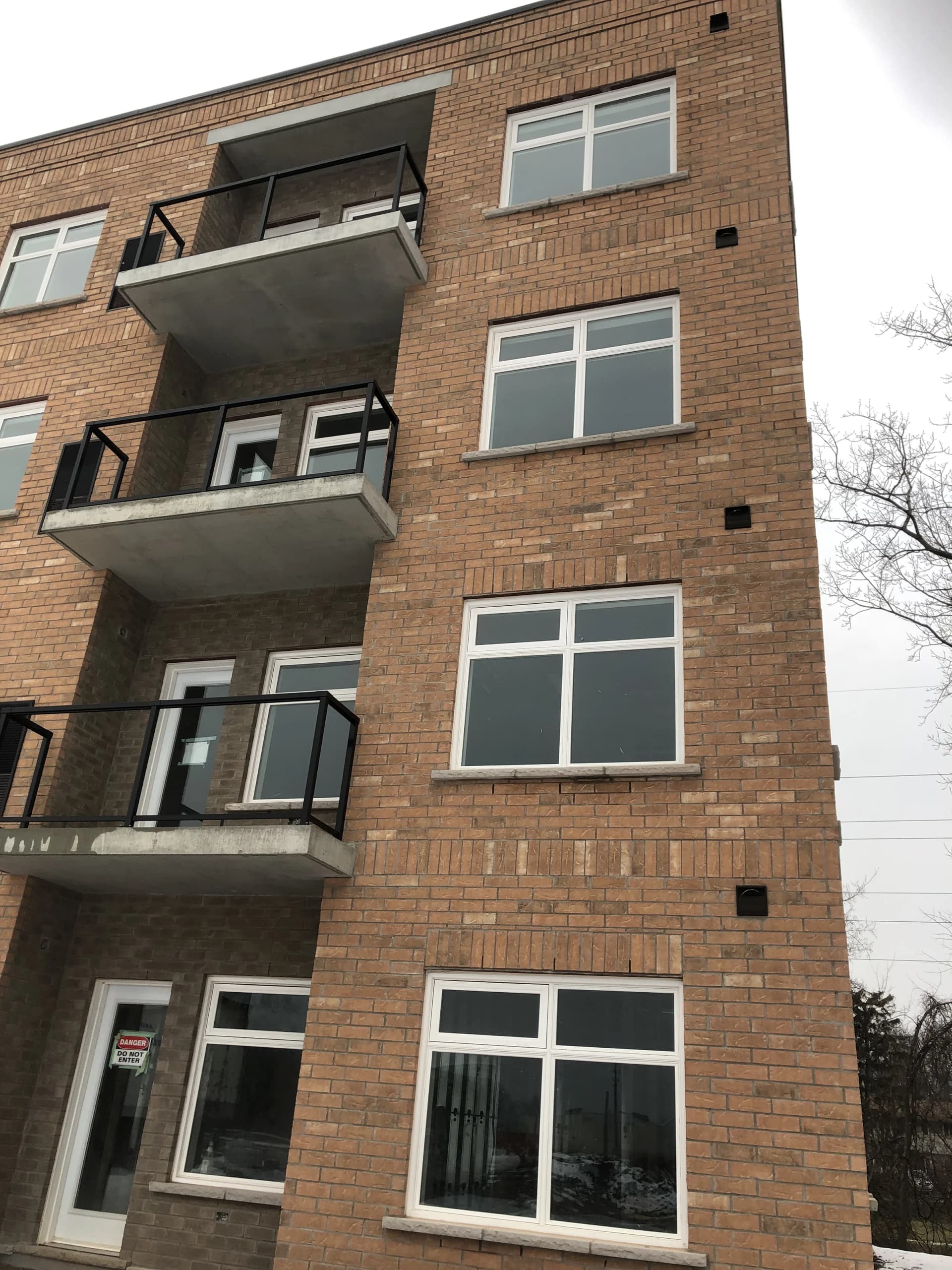 Vertical supplied photograph of stacked balconies, brick walls and ground-floor windows at 5629 Swayze Drive