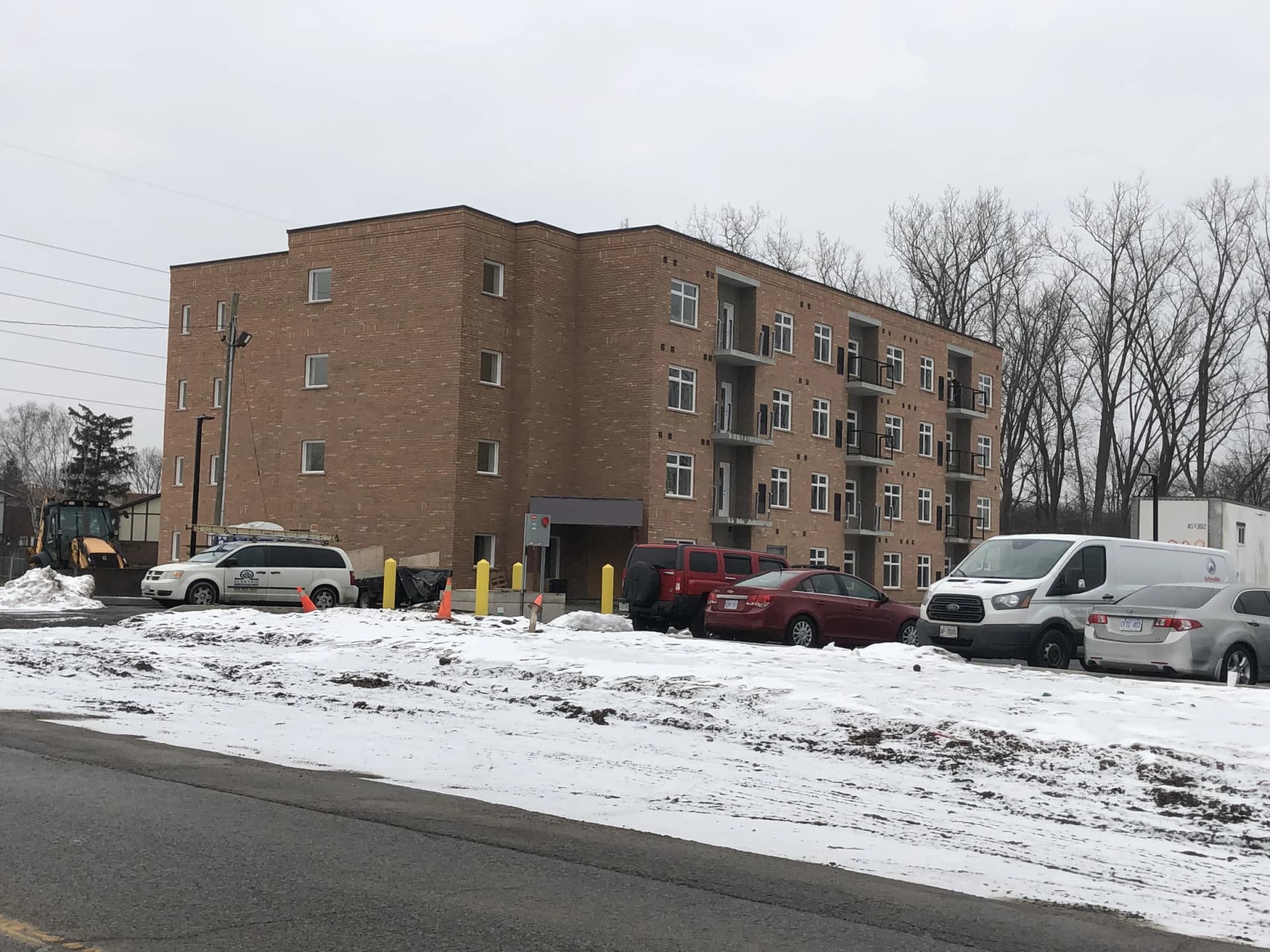 Additional supplied winter view of the apartment entrance and parking area at 5629 Swayze Drive from across the snow-covered frontage